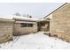Back exterior of home featuring stone siding with snowy landscape at 1401 Castle Ave, Indianapolis, IN 46227