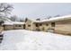 Stone exterior of the house with a snowy backyard creating a serene winter setting at 1401 Castle Ave, Indianapolis, IN 46227