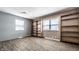 Bedroom featuring built-in shelving, two windows with blinds, and vinyl plank flooring at 1401 Castle Ave, Indianapolis, IN 46227