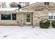 Entrance featuring a door and porch with snow-covered yard and stone facade at 1401 Castle Ave, Indianapolis, IN 46227