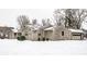 Single-story home with stone facade, lawn, and an attached garage with snow-covered yard at 1401 Castle Ave, Indianapolis, IN 46227