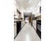 This galley-style kitchen features white cabinetry, appliances, and tiled floors at 1401 Castle Ave, Indianapolis, IN 46227
