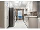 Galley kitchen features stainless steel refrigerator, and white cabinets at 1401 Castle Ave, Indianapolis, IN 46227