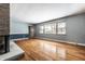 Spacious living room features a large window and a charming brick fireplace at 1401 Castle Ave, Indianapolis, IN 46227