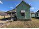 Exterior angled view showcases awning, classic design, and the potential for renovation at 1628 Sherman St, Anderson, IN 46016