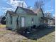 Rear exterior angled view shows the home's architecture and layout, needs renovation at 1628 Sherman St, Anderson, IN 46016