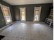 Empty living room featuring three windows letting in natural light, and a dark accent wall at 1628 Sherman St, Anderson, IN 46016