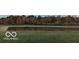 Scenic view of a calm pond surrounded by colorful trees and lush green grass at 2091 Creek Bank Dr, Columbus, IN 47201