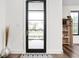 Bright entryway features a glass front door, hardwood floors, a decorative rug, and a wooden bookshelf at 2117 Broadway St, Indianapolis, IN 46202