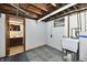 Unfinished basement features a utility sink and access to a bathroom with modern fixtures at 2521 Beechcrest Dr, Indianapolis, IN 46203
