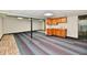 Finished basement with drop ceiling, support beams, cabinets with sink, and colorful carpet squares at 2521 Beechcrest Dr, Indianapolis, IN 46203