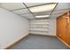 Basement with blue carpet, shelving unit and wood-paneled walls at 2521 Beechcrest Dr, Indianapolis, IN 46203