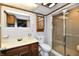 Bathroom with a glass-door shower, oak cabinets, tile flooring, and a framed mirror at 2521 Beechcrest Dr, Indianapolis, IN 46203