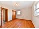 Bedroom with hardwood floors, window, closet doors, and ensuite bathroom entrance at 2521 Beechcrest Dr, Indianapolis, IN 46203