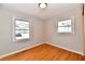 Bright bedroom with hardwood floors, baseboards, and two windows at 2521 Beechcrest Dr, Indianapolis, IN 46203