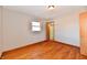 Empty bedroom showcases hardwood floors, a window, and a doorway to bathroom at 2521 Beechcrest Dr, Indianapolis, IN 46203
