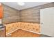 Dining area with wood paneled accent wall, light hardwood floors, and a white entry door at 2521 Beechcrest Dr, Indianapolis, IN 46203