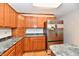 This kitchen features wood cabinets and stainless steel appliances with stone countertops and wood floors at 2521 Beechcrest Dr, Indianapolis, IN 46203