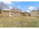 Spacious backyard with a brick home, mature trees, shed, and dormant grass at 305 Bixler Rd, Indianapolis, IN 46227