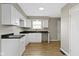 This kitchen features bright white cabinets, dark countertops, and modern wood flooring at 305 Bixler Rd, Indianapolis, IN 46227