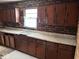Traditional kitchen with dark wood cabinets, brick backsplash, and functional layout at 317 S Harris Ave, Indianapolis, IN 46222