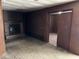 Cozy living room with a brick fireplace, paneled walls, and an open doorway at 317 S Harris Ave, Indianapolis, IN 46222