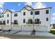 Rear view of modern townhomes with private garages and sleek black balcony railings at 4150 Douro Trl, Westfield, IN 46062