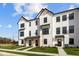 Attractive farmhouse style townhomes with contrasting black trim and beautifully landscaped front yards at 4150 Douro Trl, Westfield, IN 46062