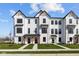 Newly built white farmhouse townhomes with black trim and inviting front yards at 4150 Douro Trl, Westfield, IN 46062