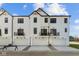 Modern farmhouse townhomes feature private garages and contemporary black balcony railings at 4150 Douro Trl, Westfield, IN 46062