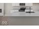 Modern kitchen island featuring quartz countertop, stainless steel appliances, and white cabinetry at 4150 Douro Trl, Westfield, IN 46062