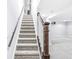 Carpeted basement stairs with a dark wood handrail lead to a finished basement space at 4305 Central Ave, Indianapolis, IN 46205