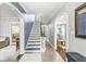 Bright hallway with hardwood floors, an ornate staircase, and arched doorways leading to other rooms at 4305 Central Ave, Indianapolis, IN 46205