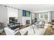 Bright living room featuring large windows, hardwood flooring, a fireplace, and stylish decor at 4305 Central Ave, Indianapolis, IN 46205