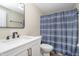 This bathroom features a white vanity with a black faucet and a shower with a blue shower curtain at 4623 Clark St, Anderson, IN 46013