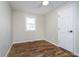 This bedroom features wood-look flooring, a ceiling fan, and a large window at 4623 Clark St, Anderson, IN 46013