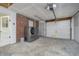 Spacious garage with washer, dryer, brick accent wall, and an automatic garage door at 4623 Clark St, Anderson, IN 46013