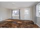 Bright living room featuring hardwood floors, a large window, and a white front door at 4623 Clark St, Anderson, IN 46013