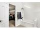 Bright bathroom with a tub, towel rack, and a view into the primary bedroom with gray and white accent wall at 4783 Briarwood Trce, Carmel, IN 46033