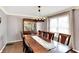 A dining room with a dark wood table set for eight in front of a large window at 4783 Briarwood Trce, Carmel, IN 46033