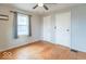 This bedroom boasts hardwood floors, neutral paint, a ceiling fan, and a large window for natural light at 4836 W 71St St, Indianapolis, IN 46268