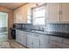 Well-lit kitchen featuring granite countertops, backsplash, stainless steel sink, and ample cabinet space at 4836 W 71St St, Indianapolis, IN 46268