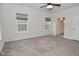 Spacious bedroom with neutral carpet, ceiling fan, two windows, and ensuite bathroom at 5176 Green Valley Ln, Noblesville, IN 46062