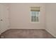 A simple bedroom with neutral walls and carpeting features a window with blinds at 5176 Green Valley Ln, Noblesville, IN 46062