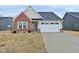 Charming home with brick and siding, showcasing a two-car garage and well-maintained lawn at 5176 Green Valley Ln, Noblesville, IN 46062