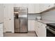 Kitchen area features stainless refrigerator, granite countertops, white cabinets, and herringbone backsplash at 5176 Green Valley Ln, Noblesville, IN 46062