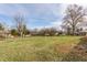 Large backyard featuring an expanse of green grass and mature trees at 5210 Ashbourne Ln, Indianapolis, IN 46226