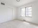 A bedroom with a window, closet, and light gray walls at 5210 Ashbourne Ln, Indianapolis, IN 46226