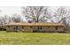 Rear exterior view of a charming brick home showcasing well-placed windows and an attached covered patio at 5210 Ashbourne Ln, Indianapolis, IN 46226