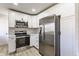 Close up of a bright kitchen showcasing white cabinetry, stainless steel appliances, quartz countertops, and modern finishes at 5210 Ashbourne Ln, Indianapolis, IN 46226